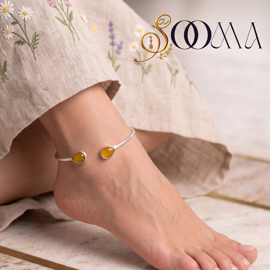 Model wearing silver open cuff ankle kada with yellow teardrop stones styled with floral embroidered dress