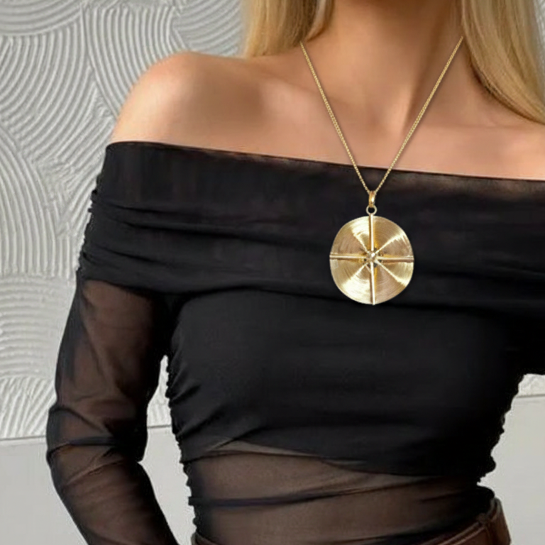 Person wearing a black off-shoulder top with golden compass unique gold plated pendant with chain, versatile .