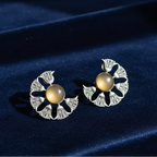 Close-up of statement oxidized stone earrings showcasing intricate stone setting and antique finish on a blue velvet background.