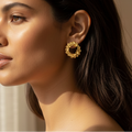 Woman wearing contemporary gold petal hoop earrings