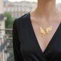 Woman wearing a black dress and elegant horse chain pendant necklace with golden finish .