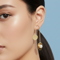 Close-up of a woman wearing elegant inverted U gold earrings.