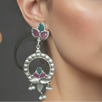 Close-up of a woman wearing of oxidized statement earrings showing intricate detailing and secure stone settings.