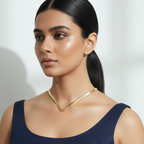 Woman wearing a navy blue dress with a minimalist gold hasli on a white background