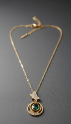Gold necklace with a pendant featuring a green gemstone & butterfly motifon a gray background