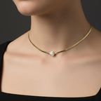 A woman wearing dainty gold necklace with a polished finish, showcasing its elegant and minimalist design.