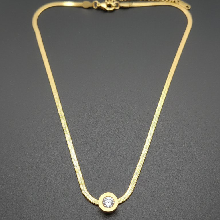 Gold necklace with a diamond stud on a dark gray background