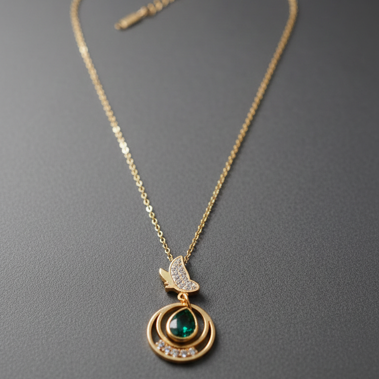 Gold necklace with a green gemstone pendant on a gray background