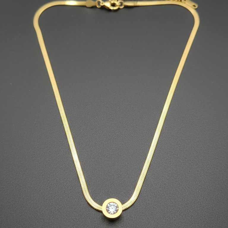 Gold necklace with a stud pendant on a dark gray background