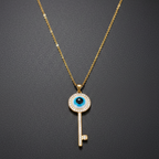 Gold necklace with a key-shaped pendant featuring anevil  eye design on a dark background