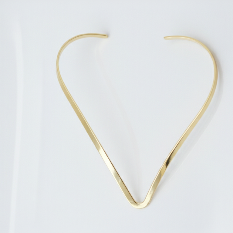Gold hasli necklace on a white background