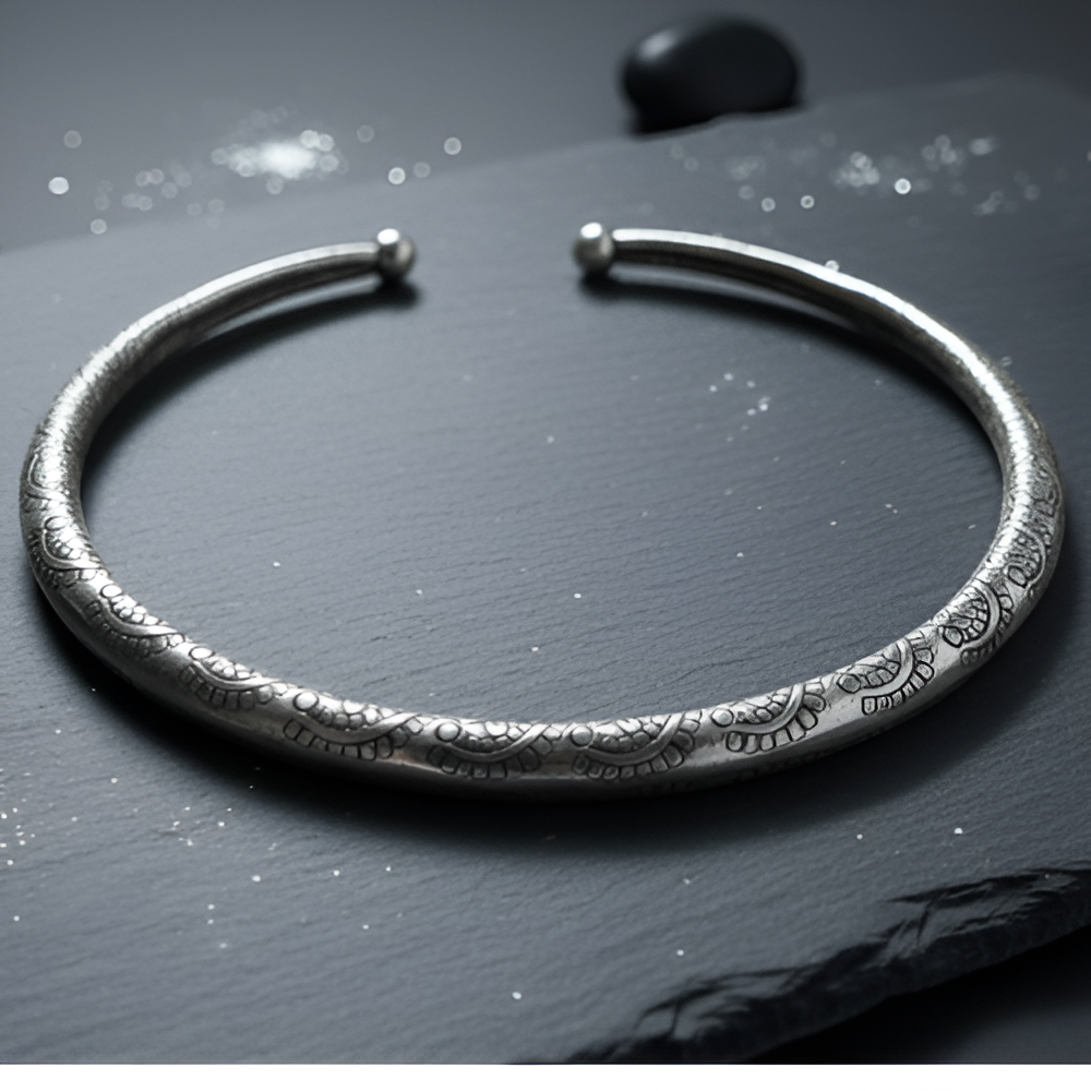 Silver hasli with textured design on a dark surface