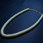Pearl necklace with gold chain on a dark blue background