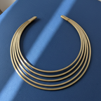 Gold hasli necklace on a blue surface