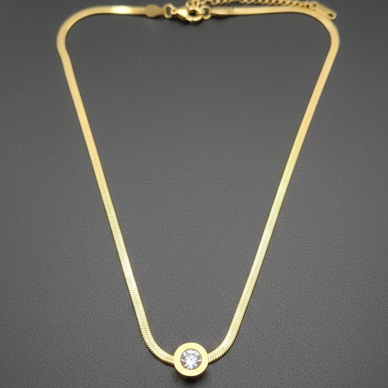 Gold necklace with a diamond stud on a dark gray background