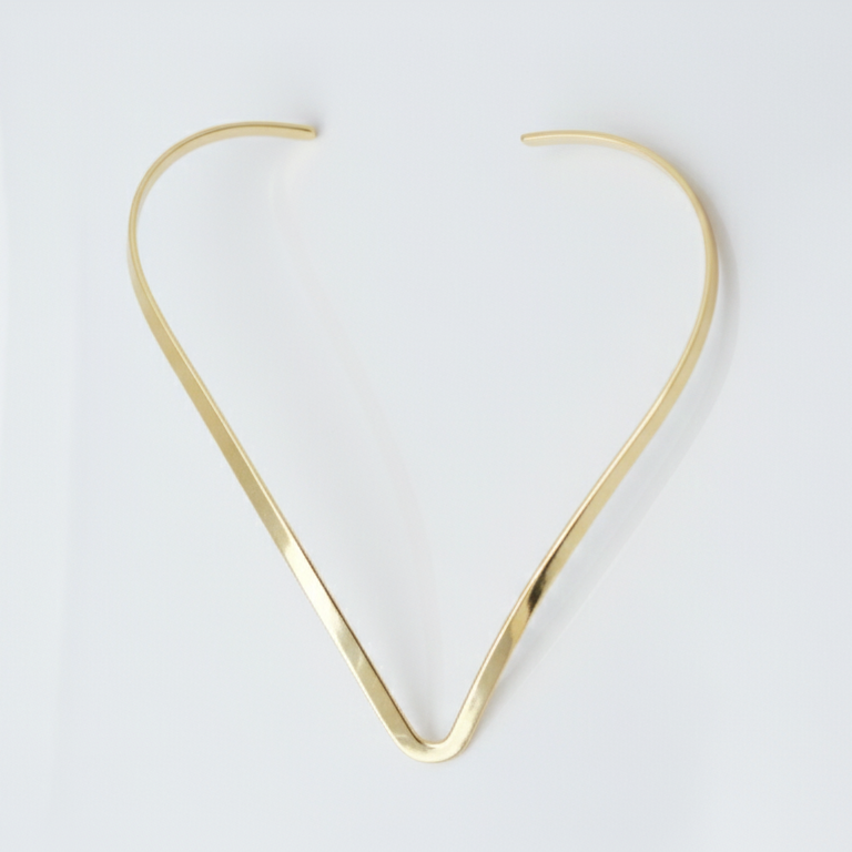 Gold hasli necklace on a white background
