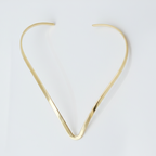 Gold hasli necklace on a white background