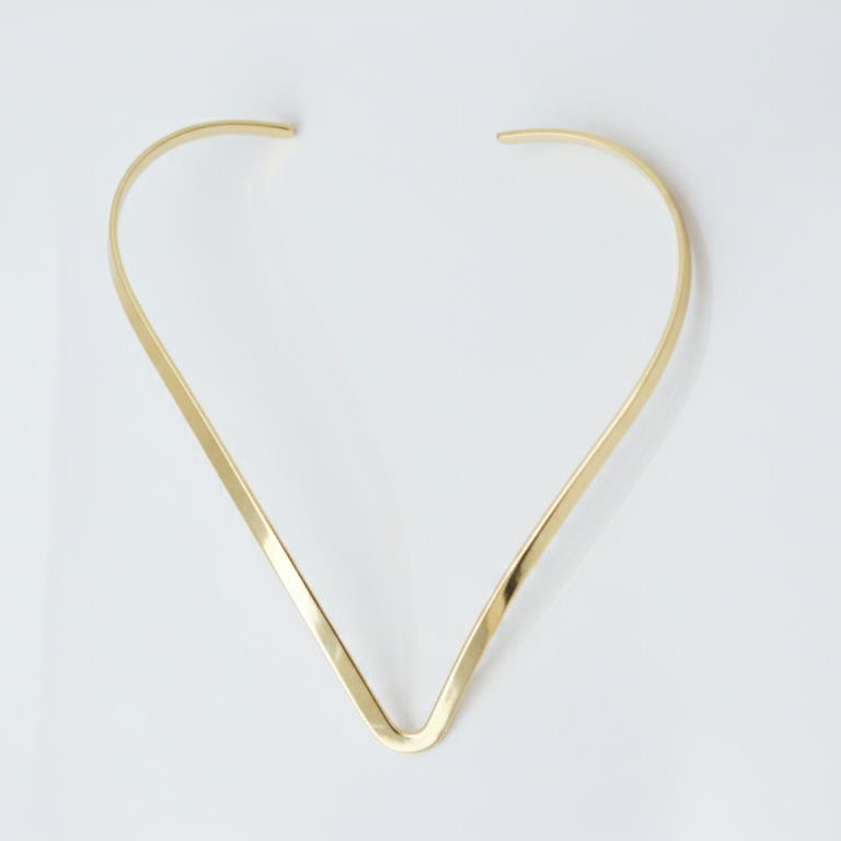 Gold hasli necklace on a white background