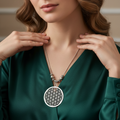 Woman wearing a green dress with a Boho silver neckpiece with intricate tribal design.