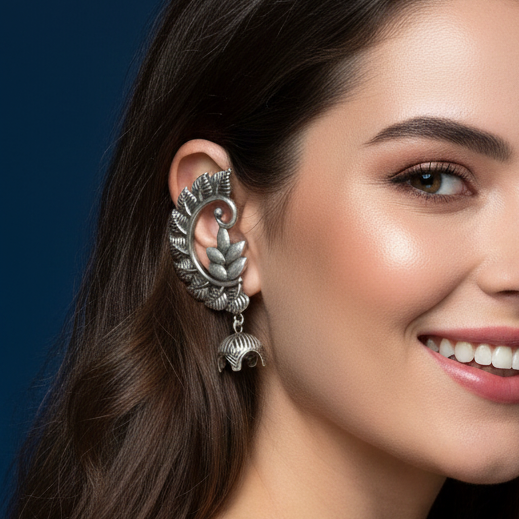 Woman wearing oxidized jhumki earcuffs showcasing intricate tribal design.