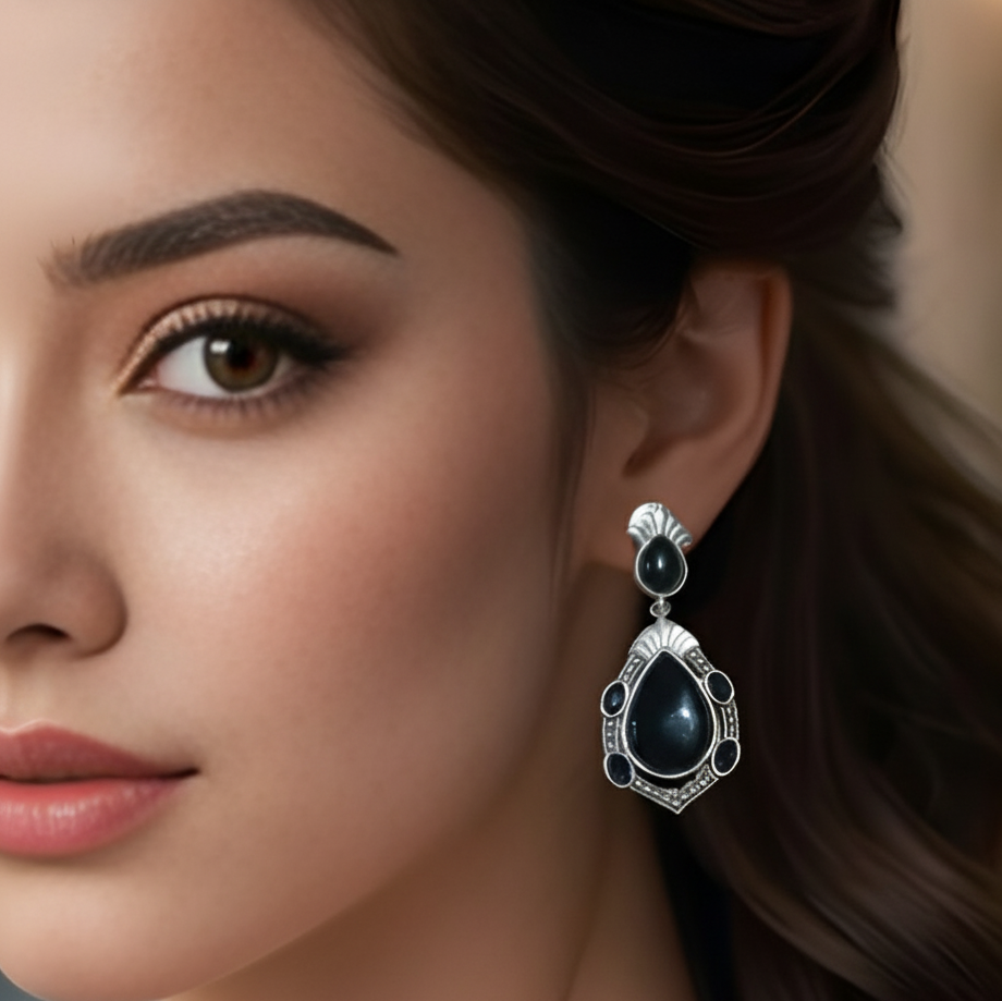 Close-up of a woman wearing black stone oxidized silver teardrop earrings