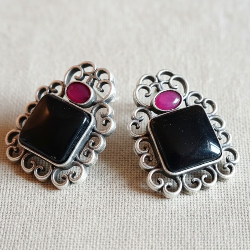 Black & Pink Oxidised stone stud earrings on a white background, close-up.