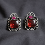 Red & Pink Oxidised stone stud earrings on a Grey background, close-up.