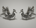 Pair of silver peacock-shaped earcuffs on a light gray background