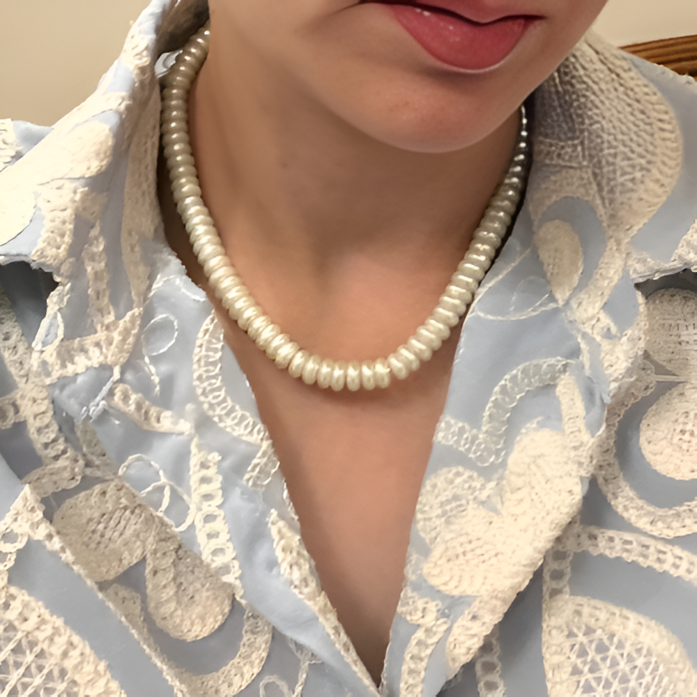 Close-up of a person wearing a pearl necklace .