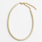 Pearl necklace with gold clasp on a white background