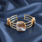 Uncut stone gold cuff bracelet imitation with raw finish for women, on a blue background .