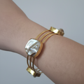 A woman's hand wearing uncut stone gold cuff bracelet imitation with raw finish 