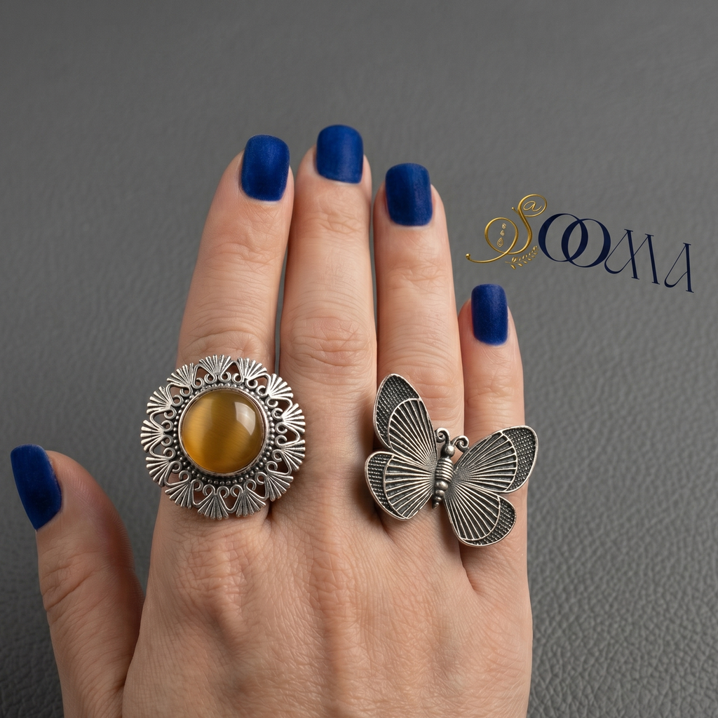 Hand wearing two rings with a gray background, featuring the brand 'Sooma'.