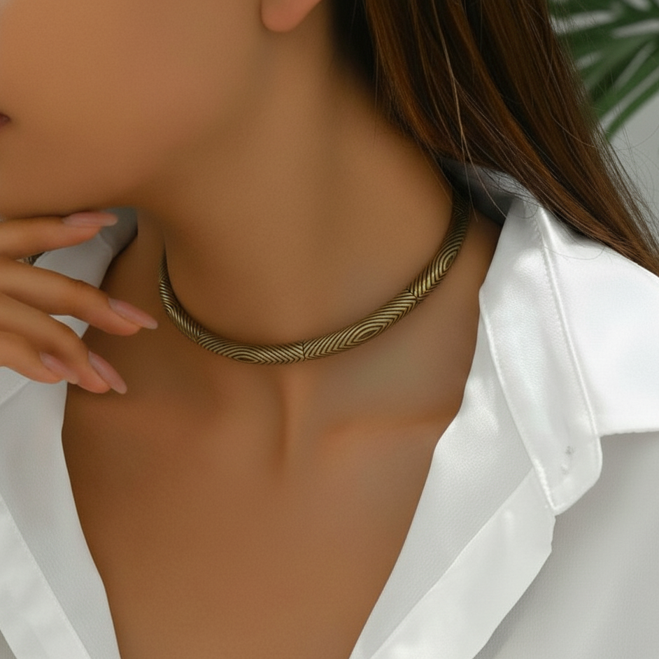 Close up of a  woman in white shirt wearing rust gold traditional hasli necklace.