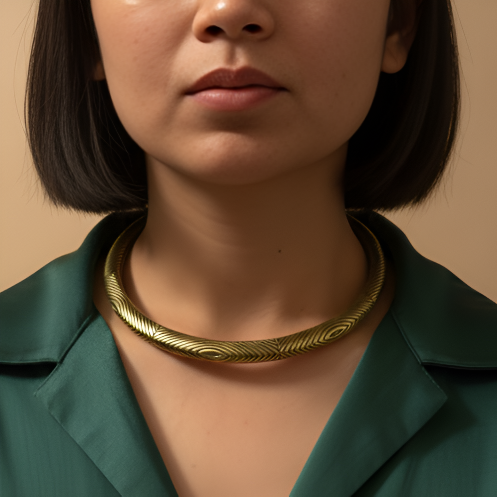 A woman wearing rust gold hasli necklace with elegant office wear.