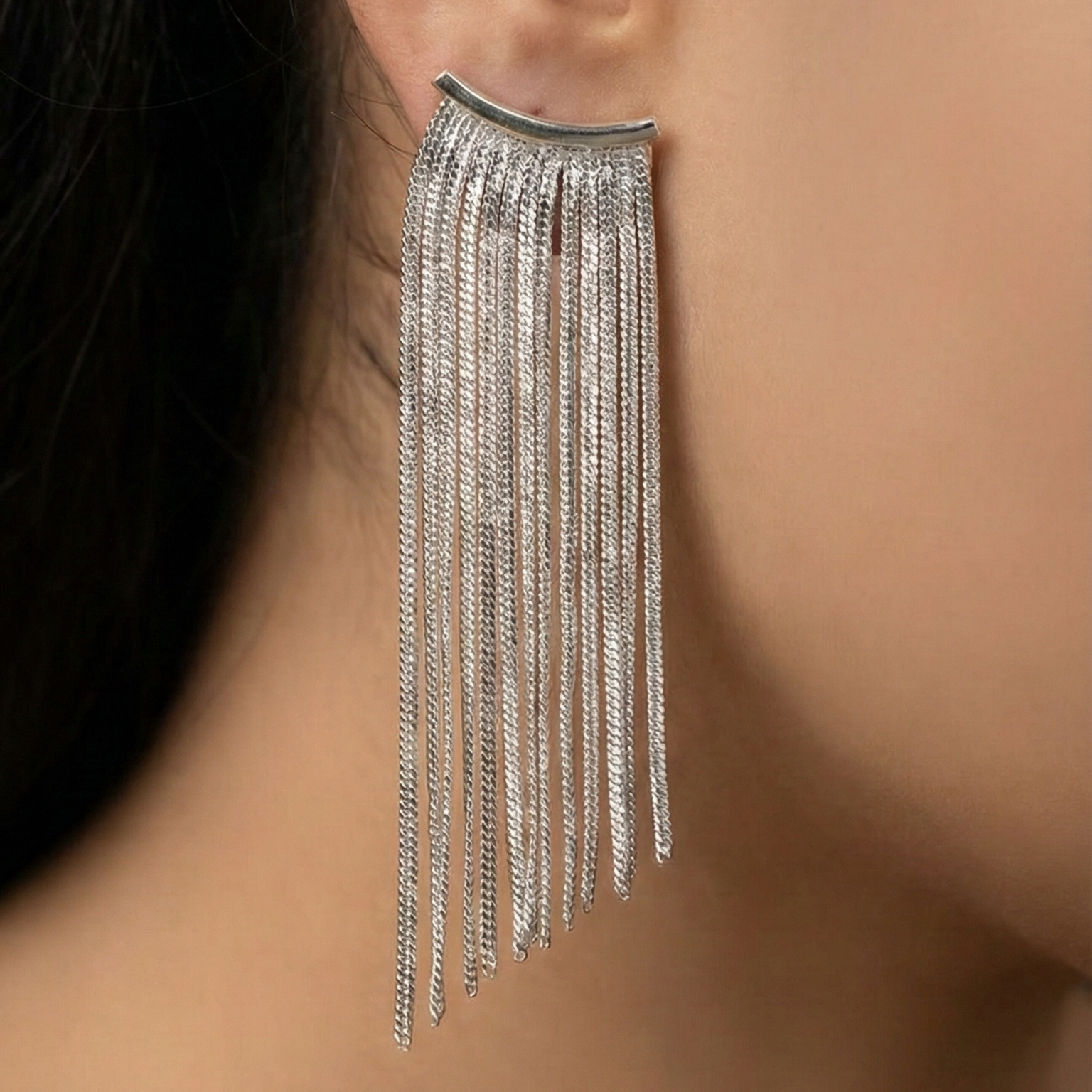 Close-up of an ear wearing Silver statement earrings with [briefly describe design, e.g., geometric pattern] 