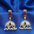 Close-up of Red Kundan drop earrings showcasing intricate stone settings. on a blue fabric background
