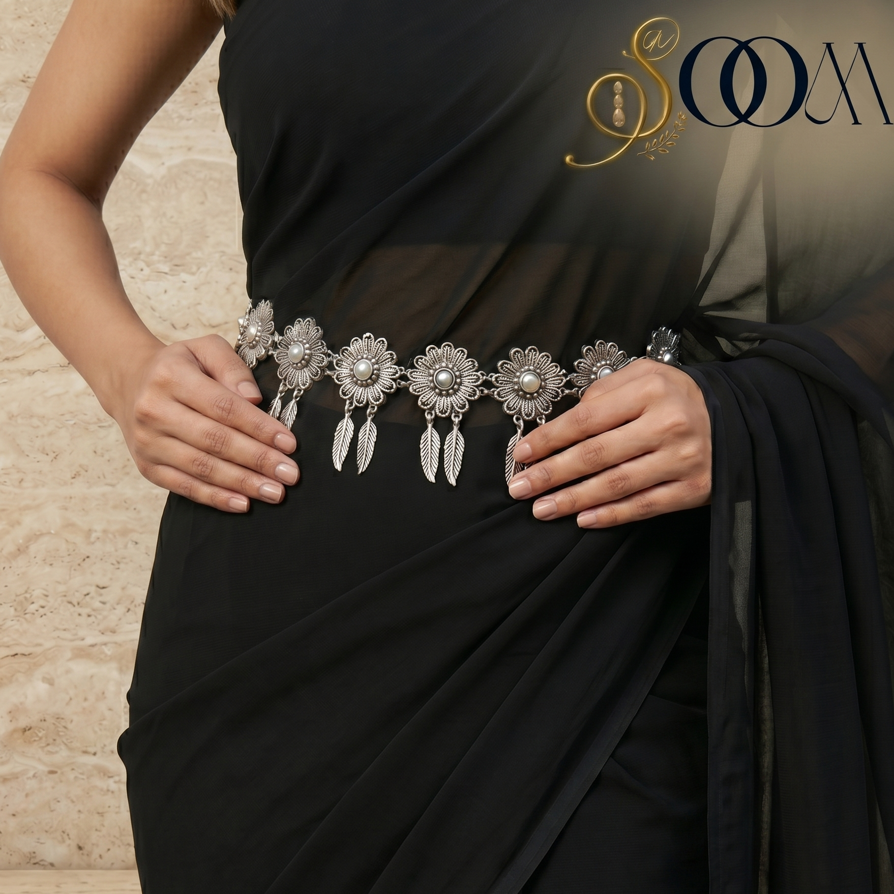 Black saree with silver jewelry belt against a neutral background, featuring the brand 'Sooma'.