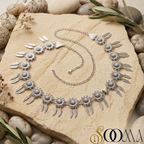 Silver waistbelt on a stone surface with a brand logo in the corner