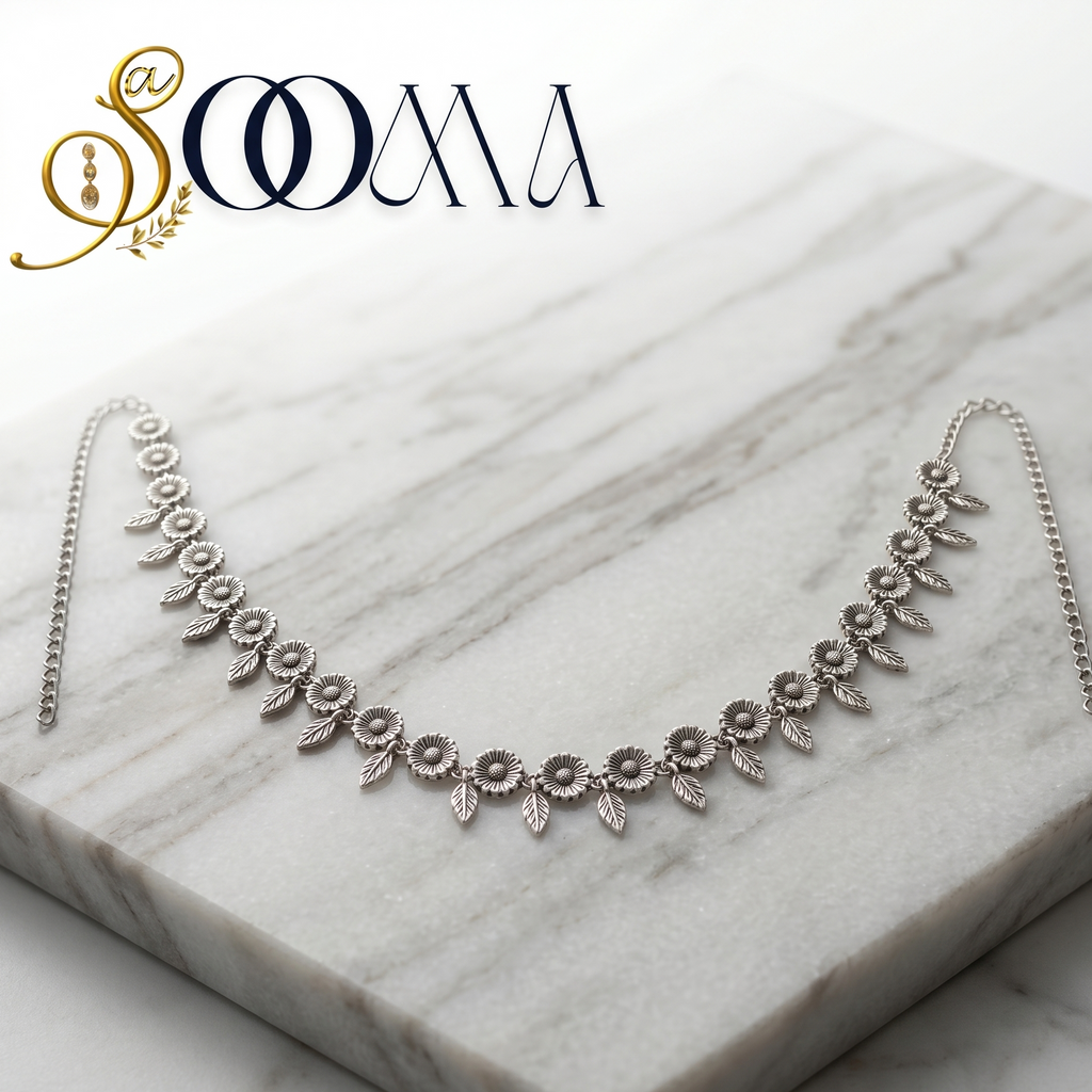 Silver belt on a marble surface with 'Sooma' branding.