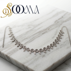 Silver belt on a marble surface with 'Sooma' branding.