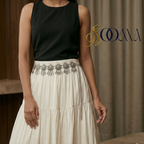 Woman wearing a black top and white skirt with Indo-Western waist belt on a woman's waist, highlighting the intricate design and elegant look, featuring the brand 'Sooma'.