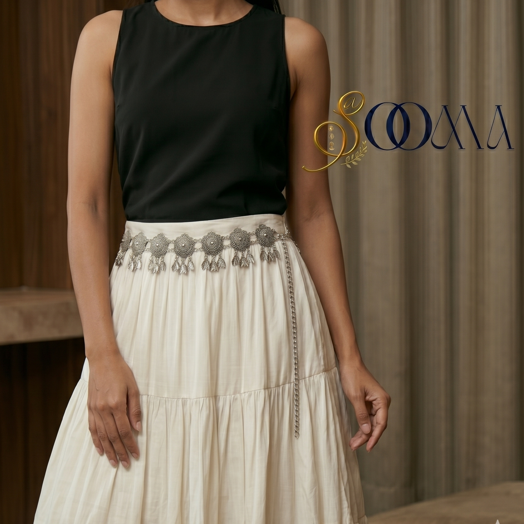 Woman wearing a black top and white skirt with Indo-Western waist belt on a woman's waist, highlighting the intricate design and elegant look, featuring the brand 'Sooma'.