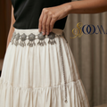 Person wearing a white skirt with Indo-Western waist belt on a woman's waist, highlighting the intricate design and elegant look.