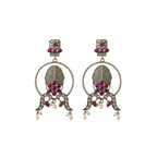 Ornate earrings with red gemstones and pearl-like elements on a white background
