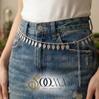 Person wearing a silver leaf belt with 'Sooma Fine Jewellery' logo.