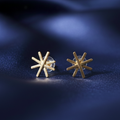  Star Gold Earrings showcasing the delicate star design and radiant gold finish on blue surface.
