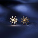  Star Gold Earrings showcasing the delicate star design and radiant gold finish on blue surface.