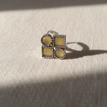 Silver ring with yellow gemstones on a textured beige surface