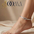 Side view of model foot wearing a sleek silver infinity knot dual-band ankle cuff on beige silk fabric